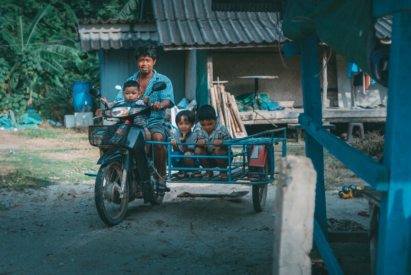 Father and his sons riding a scooter