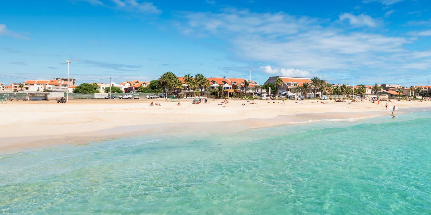 Two fishermen walking on a beach in Cape Verde island holding a